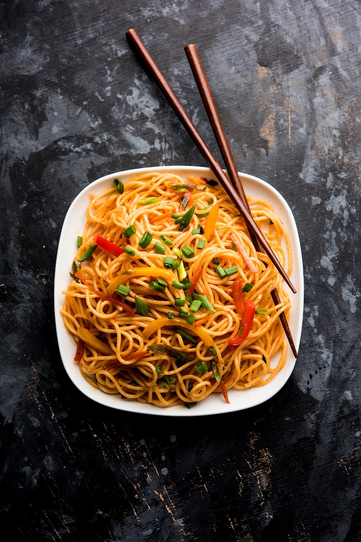 schezwan-noodles-vegetable-hakka-noodles-chow-mein-is-popular-indo-chinese-recipes-served-bowl-plate-with-wooden-chopsticks_466689-46416